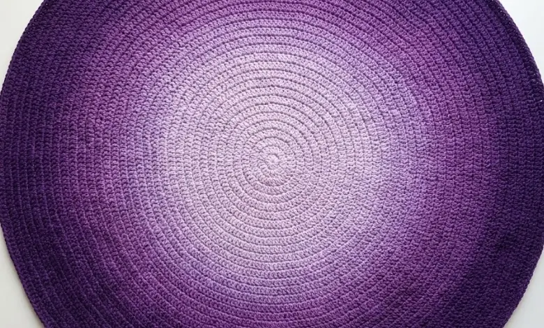 Circular crochet blanket with seamless spiral ombre color fade from pale lavender to deep purple photographed from above