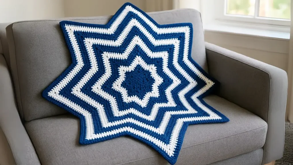 Blue and white striped 8-point star blanket crochet pattern draped on gray sofa, 42-inch diameter throw size