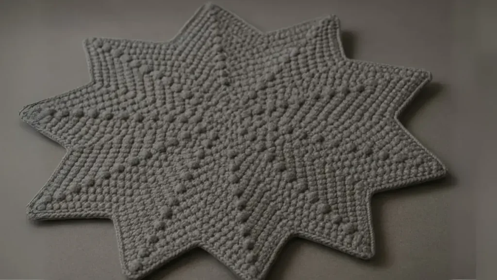 Gray bobble stitch star blanket with raised texture, dimensional crochet pattern showing detailed bobble work, 50-inch diameter