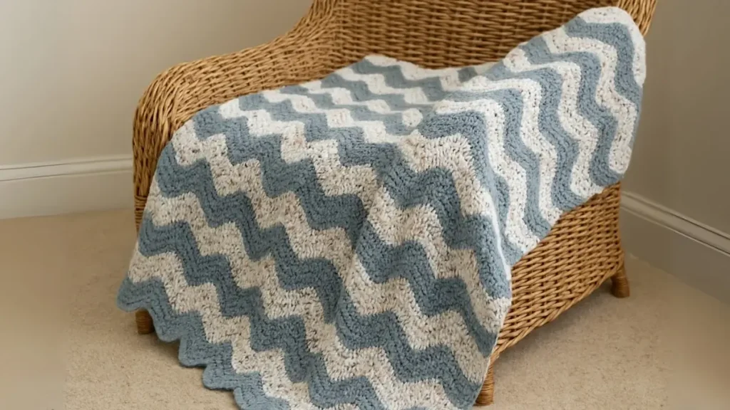 Crochet ripple blanket alternating speckled yarn and solid stripes, draped across a sofa.