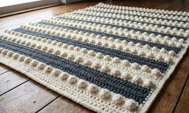Textured crochet blanket with raised bobble stitch rows alternating with smooth stripes in two contrasting colors