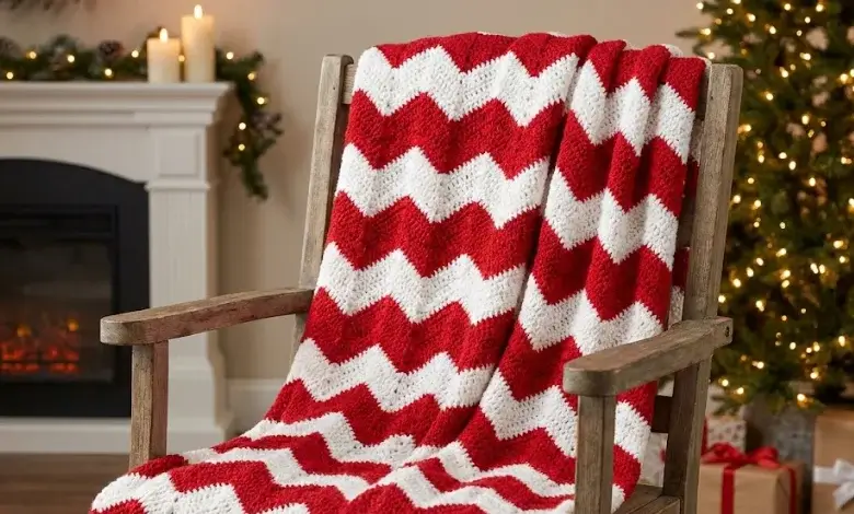 Red and white crochet chevron blanket draped over a farmhouse chair near a Christmas tree