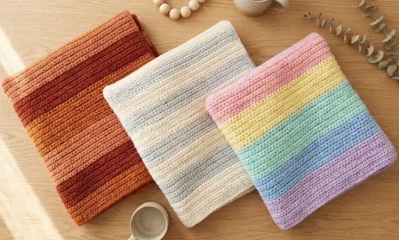 Collection of colorful crochet striped blankets draped over furniture in a cozy living room