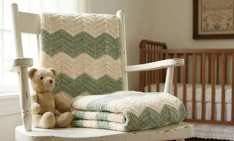 Cream and sage green crochet chevron toddler blanket folded on a white rocking chair